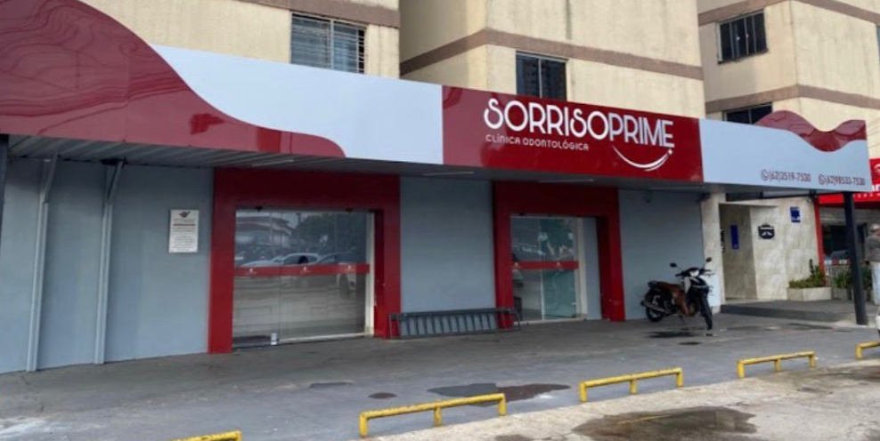 Fachada da clínica Sorriso Prime, com o letreiro vinho e branco
